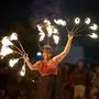 Eine lachende Frau macht eine Feuershow und wirbelt mit mehreren Feuerbällen in der Luft | Für 2026 stehen viele Events auf dem Programm im Bezirk