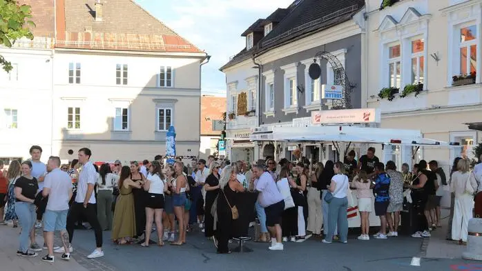 Ein Foto von vielen Menschen am Feldkirchner Hauptplatz während einer Afterwork-Veranstaltung.