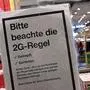 ABD0007_20211222 - MÜNCHEN - DEUTSCHLAND: 22.12.2021, Bayern, München: Ein Schild mit der Aufschrift ·Bitte beachte die 2G-Regel - Geimpft - Genesen· hängt am Eingang zu einem Ladengeschäft in der Innenstadt. Foto: Peter Kneffel/dpa +++ dpa-Bildfunk +++. - FOTO: APA/dpa/Peter Kneffel