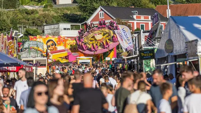 Zu sehen sind viele Menschen, die sich auf einem Marktgelände tummeln