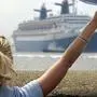 epa000440763 A young woman waves a handkerchief to bid a final farewell to the former cruise liner 'Norway', the former largest passenger vessel in world, as the ship departs for Malaysia from Bremerhaven, Germany, Monday, 23 May 2005. The cruise liner and former flagship of the Norwegian ship owning company Norwegian Cruise Line (NCL) may even be scrapped. After a boiler explosion two years ago in Miami, USA, the 315 meter vessel was meant to be repaired and then sold at first. However, no buyer was found and the Norway is now on her way to an uncertain futures in the Far East. EPA/Ingo Wagner