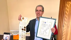 Ein Mann hält Urkunde in die Kamera