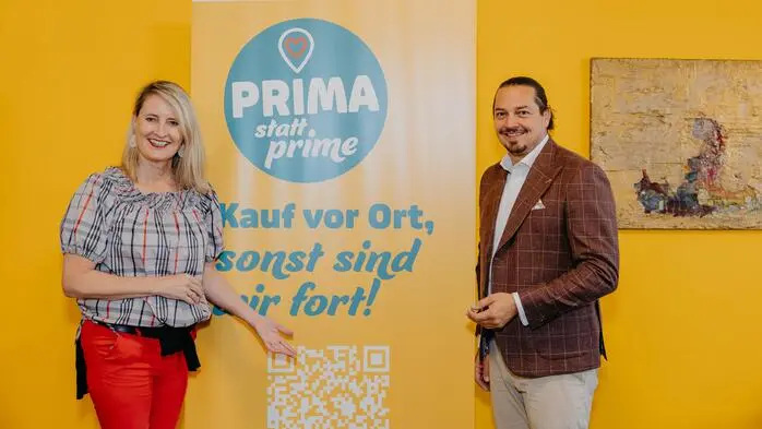 Ein Mann und eine Frau posieren für ein Foto und lächeln in die Kamera.
