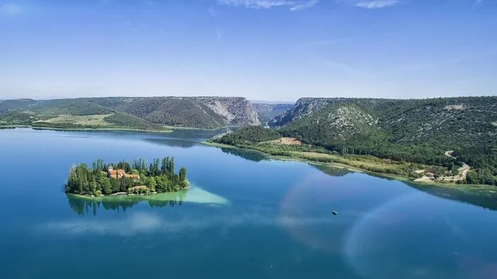 Der Nationalpark Krka verdankt seinen Namen dem durch den Park fließenden Fluss Krka. Die Quelle des Flusses befindet sich im Karstgebirge in der Nähe von Knin, von wo aus er sich 73 Kilometer lang durch das Flussbett windet und bei Sibenik in die Adria mündet. Mit seinen sieben Travertin Wasserfällen stellt der Fluss Krka ein Natur- und Karstphänomen dar. Inmitten des Visovac Sees liegt die gleichnamige Insel, auf welcher sich ein Franziskanerkloster und eine Kirche seit 1445 befinden und von einem prächtigen Gelände umgeben sind.