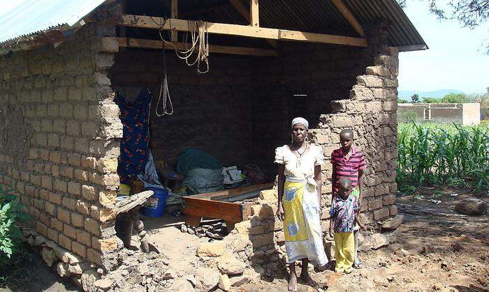 Eine betroffene Familie in der Mara-Region vor ihrem zerstörten Haus
