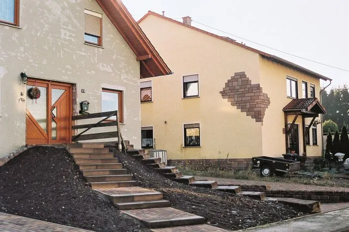 Dekorative Putzschäden in Göttelborn. In Fröbes aktuellem Buch „Eigenwillige Eigenheime" trifft man auf falsche Schlösser, endlose Kiesgärten, aber auch auf aufgemalte Züge, die direkt aus dem Fassaden-Bahnhof auf die Passanten losrasen.