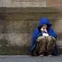 TOPSHOT - A homeless person crouches beside a wall in a Glasgow city centre street on March 27, 2020. - Britain is under lockdown, its population joining around 1.7 billion people around the globe ordered to stay indoors to curb the "accelerating" spread of the coronavirus. (Photo by ANDY BUCHANAN / AFP)