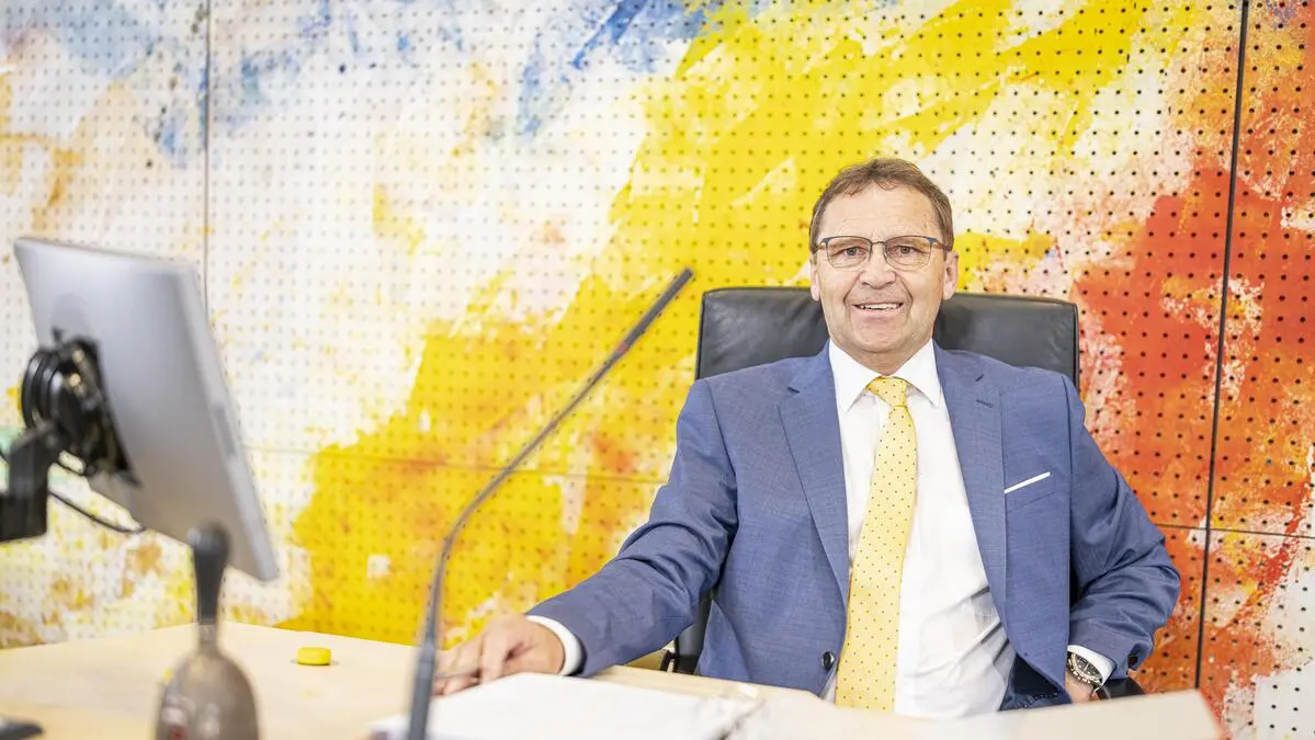 Mann im Anzug sitzt an Tisch