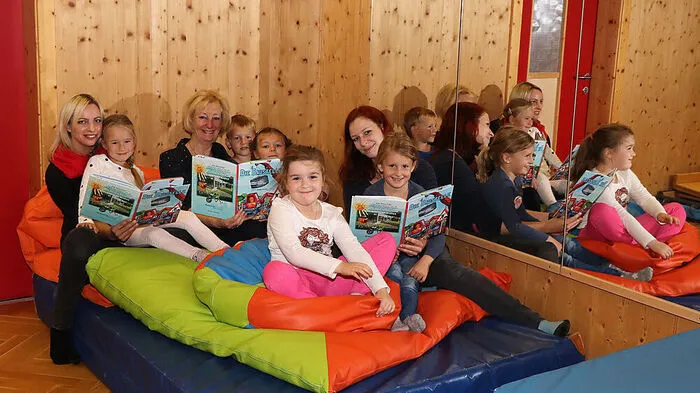 Haben ein Bilderbuch mit vielen Bildern und Geschichten gestaltet: Gerlinde Kollegger, Janet Rose und Ulrike Rutar (von links) mit Kindern des Kindergartens