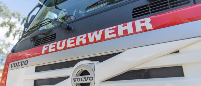 Eine nahe Aufnahme eines Feuerwehrautos. Darauf ist deutlich das Wort „Feuerwehr“ zu lesen.