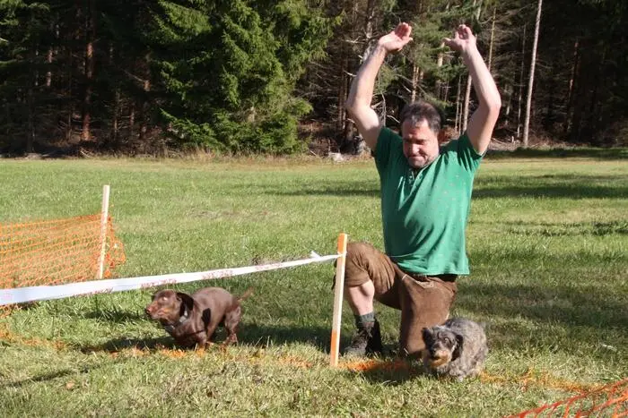 Eine Person lässt den Hund los, eine weitere wartet im Ziel auf ihn