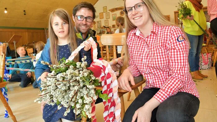 Magdalena Bliem (rechts) hat Emma Bliem und deren Papa Mario Glawischnig beim Palmstangen-Binden unterstützt.