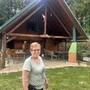 Eine ältere Dame steht vor einer Hütte 