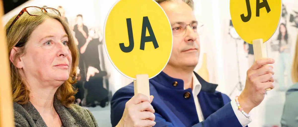 KPÖ-Chefin Elke Kahr und ÖVP-Chef Kurt Hohensinner halten im Rahmen einer Schuldiskussion im Wahlkampf beide ein Taferl mit „Ja“ in die Luft