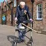 TOPSHOT - British World War II veteran Captain Tom Moore, 99, poses with his walking frame doing a lap of his garden in the village of Marston Moretaine, 50 miles north of London, on April 16, 2020. - A 99-year-old British World War II veteran Captain Tom Moore on April 16 completed 100 laps of his garden in a fundraising challenge for healthcare staff that has "captured the heart of the nation", raising more than £13 million ($16.2 million, 14.9 million euros). "Incredible and now words fail me," Captain Moore said, after finishing the laps of his 25-metre (82-foot) garden with his walking frame. (Photo by Justin TALLIS / AFP)