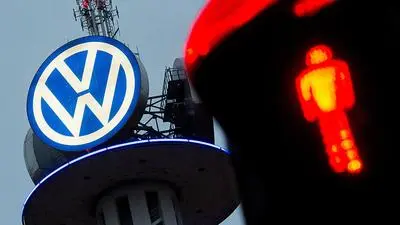 ABD0008_20161118 - ARCHIV - Ein großes Logo von Volkswagen leuchtet am 04.02.2016 in der Morgendämmerung auf dem VW-Tower in Hannover (Niedersachsen) - fotografiert mit einer roten Fußgängerampel. Volkswagen hat sich mit dem Betriebsrat auf den Abbau von weltweit bis zu 30 000 Arbeitsplätzen in den kommenden Jahren geeinigt, um die angeschlagene Kernmarke VW wieder flott zu machen. Foto: Julian Stratenschulte/dpa (zu dpa "VW baut weltweit 30 000 Stellen ab" vom 18.11.2016) +++(c) dpa - Bildfunk+++