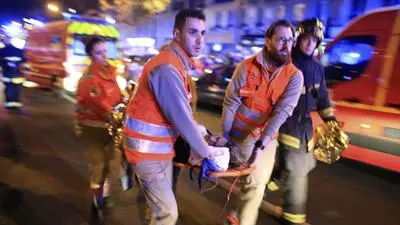 FILE - Medics evacuate a woman from the Bataclan concert hall after a shooting in Paris Nov. 13, 2015. France's first Olympics in a century promise to be some of the most breathtaking — and tricky — taking place in a gorgeous and universally beloved capital city that has been rocked in recent years by ugly terrorist attacks, police violence and anti-government protests. (AP Photo/Thibault Camus, File)