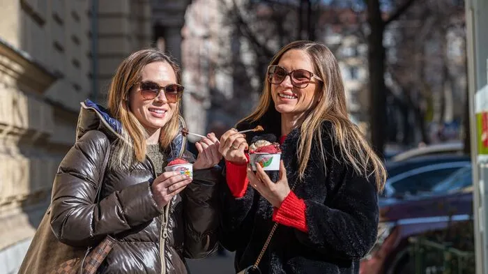 Die Zwillinge Stefanie und Alexandra genießen ihr Eis in den warmen Sonnenstrahlen