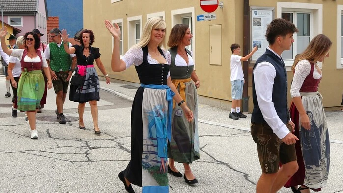 Blonde Frau in Tracht winkt in die Kamera