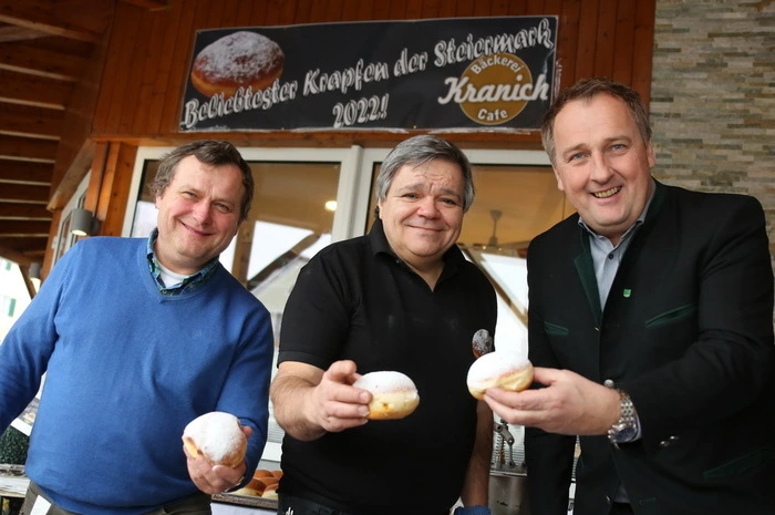 Vor dem Biss. Dechant Wolfgang Toberer, Krapfenkönig Kurt Kranich und Bürgermeister Reinhold Ebner.