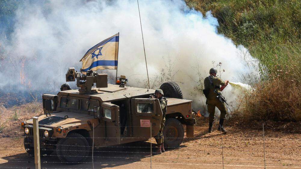 Israelische Soldaten beim Löschen eines Buschbrandes nach einem Angriff, hier an der Grenze zum Libanon. 