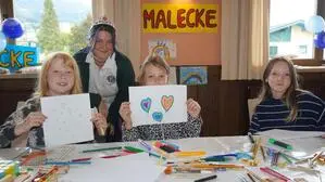 Kinder strahlen und halten ihre Zeichnungen hoch | In der Malecke entstanden kreative Zeichnungen