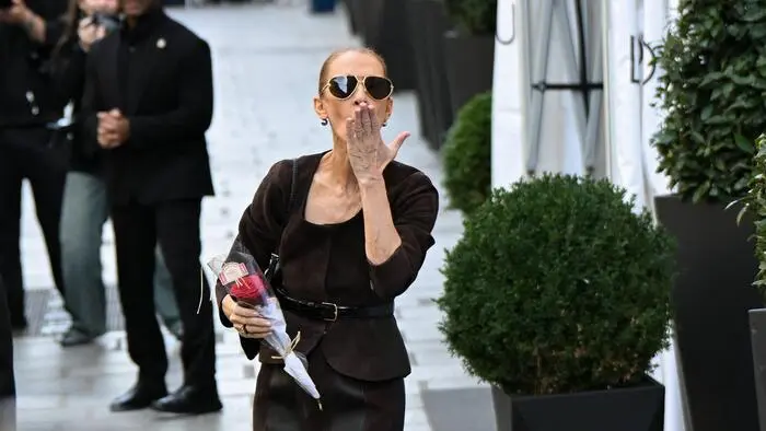 Céline Dion hält sich ihre linke Hand vor den Mund.