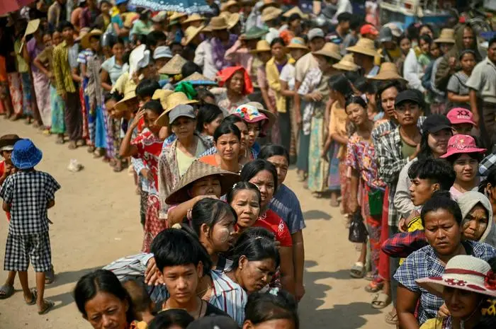 TOPSHOT - People line up for food aid being distributed in Sagaing on April 3, 2025, following the March 28 earthquake. The shallow 7.7-magnitude earthquake on March 28 flattened buildings across Myanmar, killing more than 3,000 people and making thousands more homeless. (Photo by Sai Aung MAIN / AFP)
