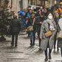 Einkaufen mit Vorsicht: Viele Menschen tragen auch im Freien eine Maske