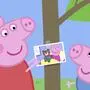 Mama Wutz aus der Kinderserie Peppa Wutz zeigt einem ihrer Kinder ein Foto | Familie Wutz freut sich auf Nachwuchs