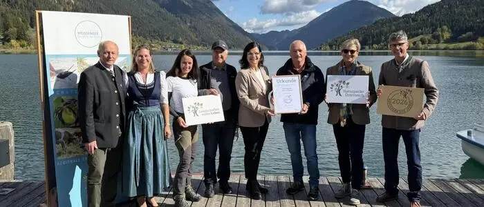 Hans-Jörg Kerschbaumer, (Bürgermeister Stockenboi), Karoline Turnschek (Bürgermeisterin Weißensee), Julia Friedlmayer (Geschäftsführerin VNÖ), Franz Schier (Naturpark-Vorsitzender), Landesrätin Marika Lagger-Pöllinger, Johann Thauerböck (Präsident VNÖ), Barbara Pucker (Amt der Kärntner Landesregierung) und Robert Heuberger (Naturpark-Geschäftsführer)