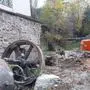 Schutt, großes Metallrad, Baggerschaufel vor Steinwand | Die Ablagerung von Abbruchmaterial und Baugerät direkt neben dem Industriedenkmal ging dem Besitzer zu weit