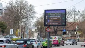 Autos auf einer Straße, neben der eine digitale Anzeige freie Parkplätze ausweist