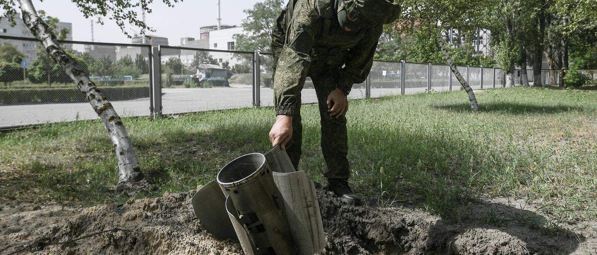 Unter Beschuss: ein Soldat inspiziert einen Einschlag am AKW-Gelände.