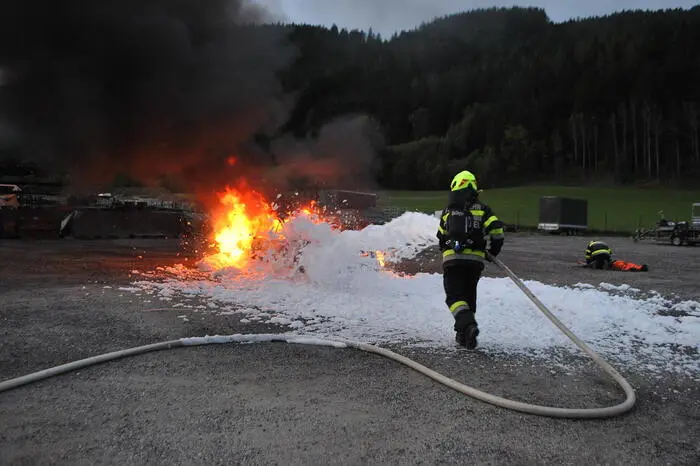 Angenommen wurde, dass der PKW von einem verletzten Mitarbeiter ins Freie gebracht wurde, konnte jedoch nicht gelöscht werden und steht brennend im Freien. Der Mitarbeiter ist schwer verletzt und bricht schließlich in der Nähe des brennenden Fahrzeuges zusammen. In der brennenden und verrauchten Halle werden Mitarbeiter eingeschlossen beziehungsweise vermisst.