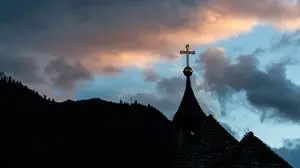 THEMENBILD - ein Kreuz auf dem Dach einer Kapelle gegen den Wolkenverhangenen Abend Himmel mit Bergen fotografiert. Am 1. November, gedenken Katholiken aller Menschen, die in der Kirche als Heilige verehrt werden. Das Fest Allerseelen am darauf folgenden 2. November, ist dem Gedaechtnis aller Verstorbenen gewidmet, aufgenommen am 30.10.2016, Kaprun, Oesterreich // A cross on the roof of a chapel photographed against the cloudy evening sky with Mountains, on All Saints' Day 1st November, Catholics remember all people who are venerated as saints in the church. The festival Souls on the following second November is dedicated to the memory of all deceased, taken at the cemetery in Kaprun, Austria on 2016/10/30. EXPA Pictures © 2016, PhotoCredit: EXPA/ JFK