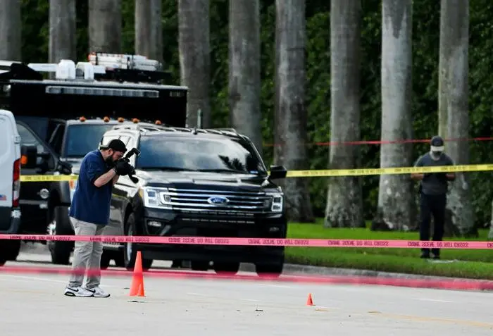 An FBI agent takes picture of the evidence of the crime scene outside the Trump International Golf Club in West Palm Beach, Florida, on September 15, 2024 following a shooting incident at former US president Donald Trump's golf course. Trump's campaign reported Sunday that there had been 