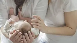 Neugeborenes in den Armen einer Frau | Hebammen arbeiten unter strengen Regeln