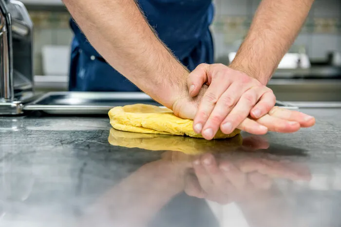 Der Pastateig wird für die Nudelmaschine vorbereitet.