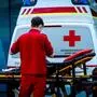 Man sieht einen Rettungssanitäter von hinten vor einem Rettungswagen stehen