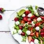 Plate of vegetarian summer salad with lime, arugula, strawberries, mozzarella, mint and daisies SARF04600 