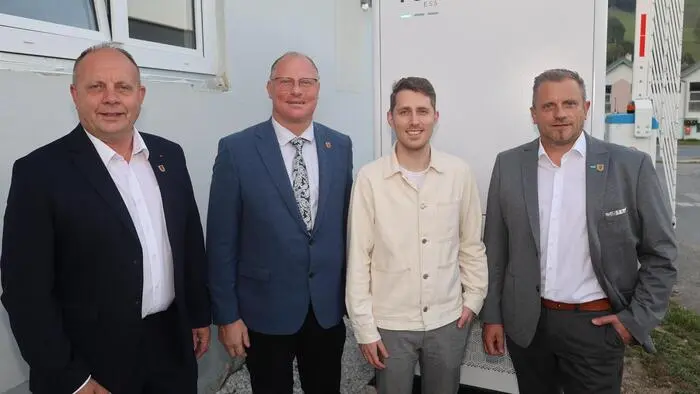 Vier Männer stehen nebeneinander und lachen in die Kamera