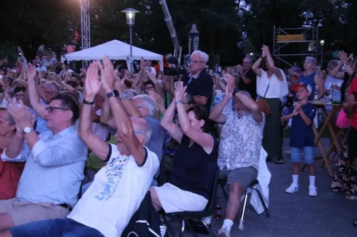 Die beiden Obmann-Stellvertreter der Bergkapelle stimmten das Publikum auf das Ereignis ein, ehe die Musikerinnen und Musiker mit einem Autobus, begleitet von Motorrädern, in den Stadtpark vorfuhren.
