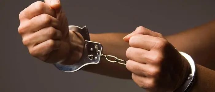 Man sieht Hände in Handschellen