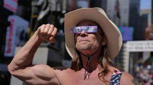 Der berühmte „Naked Cowboy“ mit der Sonnenfinsternis-Brille gestern in New York - mittlerweile eine Ikone im Big Apple