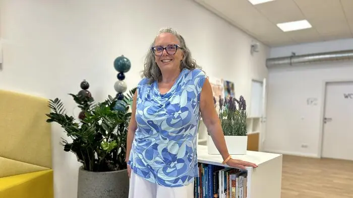 Eine Frau steht vor einem Bücherregal