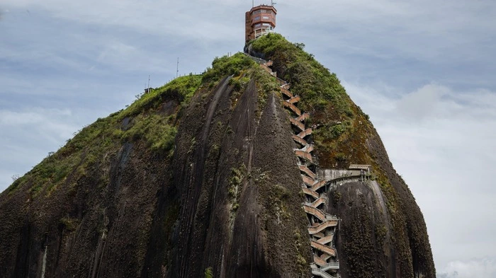 Rund 220 Meter hoch und 70 Millionen Jahre alt, bettet sich der Inselberg aus Granit in die Landschaft ein. Im Zickzack führen die Stufen hinauf zum Gipfel, von dem aus man kilometerweit sehen kann.
