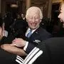 King Charles III smiles as he is embraced by member of New Zealand's Black Ferns rugby union team at Buckingham Palace in London, England, Wednesday Sept. 11, 2024. (Aaron Chown/pool photo via AP)