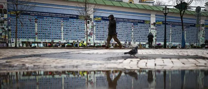  Eine Person geht an der Mauer der Erinnerung an die Gefallenen für die Ukraine in Kiew entlang