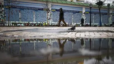  Eine Person geht an der Mauer der Erinnerung an die Gefallenen für die Ukraine in Kiew entlang